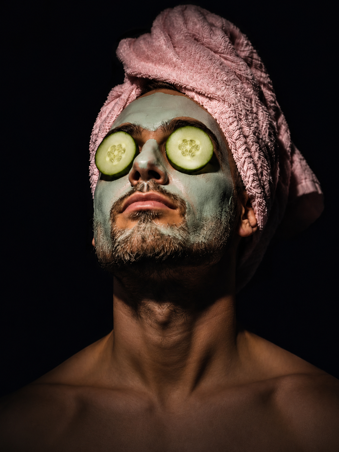 Mann mit Gesichtsmaske und Gurkenscheiben